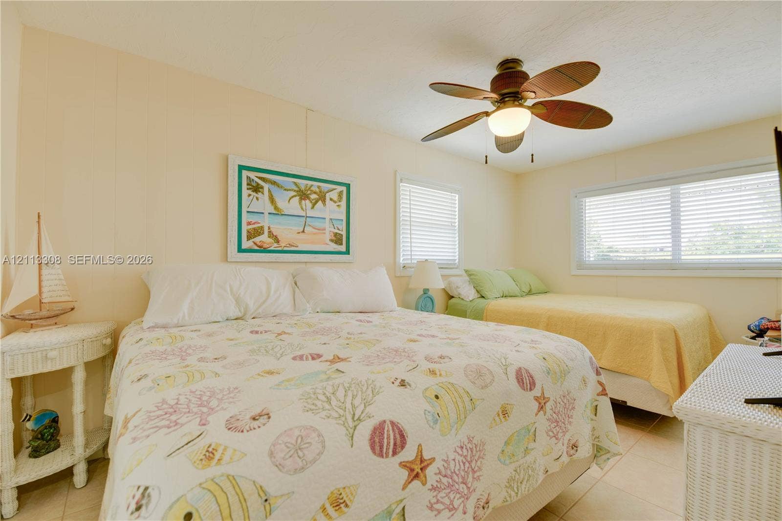 Neutral wall paneling, tile flooring, and a ceiling fan with integrated lighting