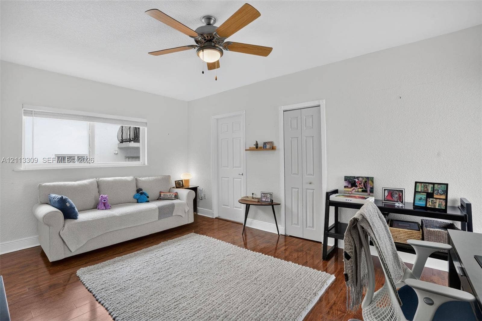 3082 Bird Avenue, #6, Miami, FL 33133 Wood-finish flooring, multi-pane sliding window, ceiling-mounted light fixture with fan, and two-panel interior doors