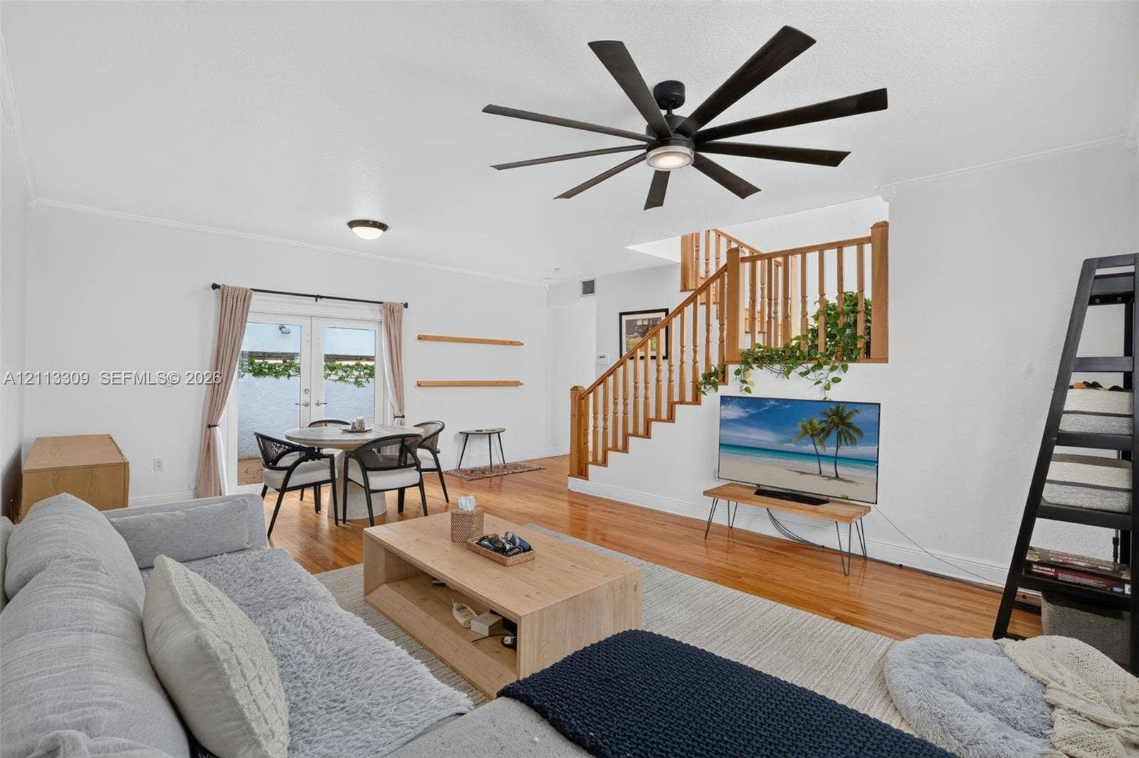 3082 Bird Avenue, #6, Miami, FL 33133 Wood-finish flooring, multi-blade matte black ceiling fan, and wooden staircase featuring a matching railing