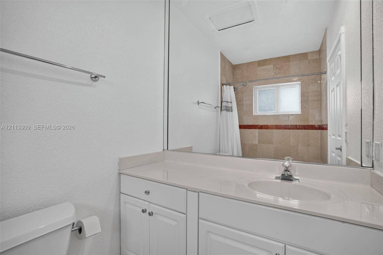3082 Bird Avenue, #6, Miami, FL 33133 Bathroom featuring a white vanity with a solid surface countertop, an integrated sink, a full-width vanity mirror, and a tub-shower combination with tile surround