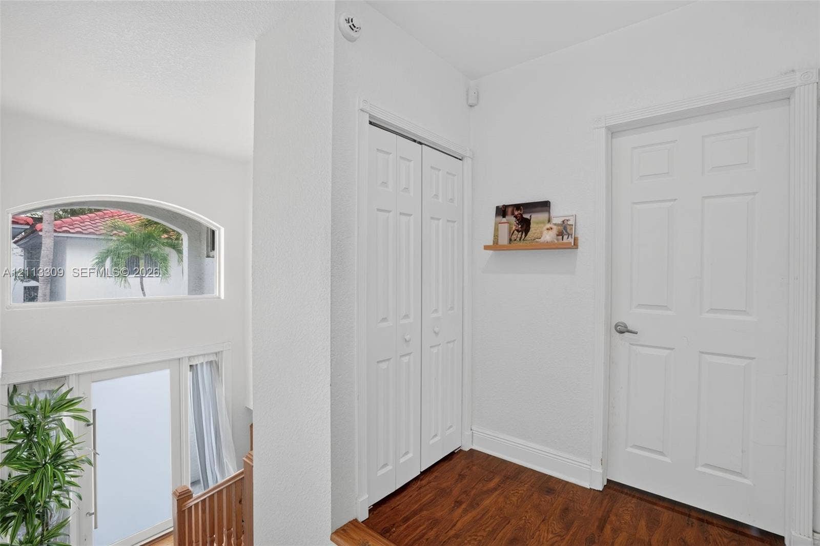 3082 Bird Avenue, #6, Miami, FL 33133 Wood-finish flooring, white paneled interior doors, bi-fold closet doors, and a semi-circular fixed window