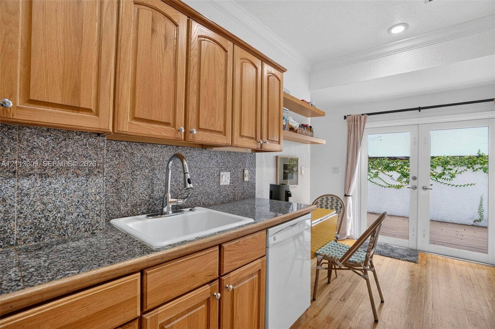 3082 Bird Avenue, #6, Miami, FL 33133 Kitchen featuring wood cabinetry, stone-surface countertop, integrated white sink with pull-down faucet, recessed ceiling lighting, and double glass-panel doors