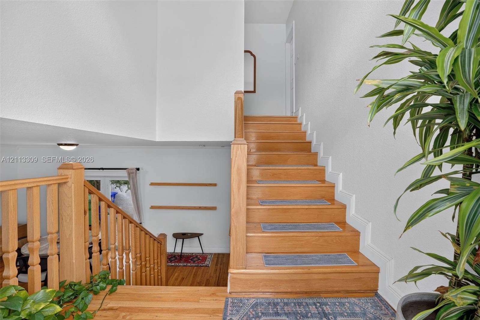 3082 Bird Avenue, #6, Miami, FL 33133 Staircase featuring natural wood handrails, wood-finish treads, and built-in shelving
