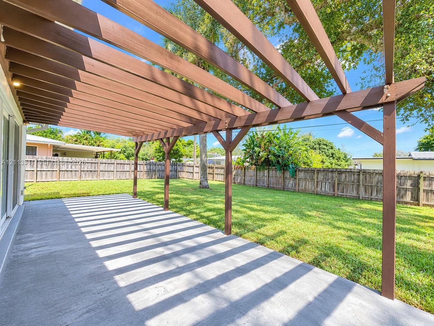 152 SW 59th Avenue, Plantation, Plantation, FL 33317 Outdoor patio featuring a stained wood pergola, concrete flooring, and a fenced backyard