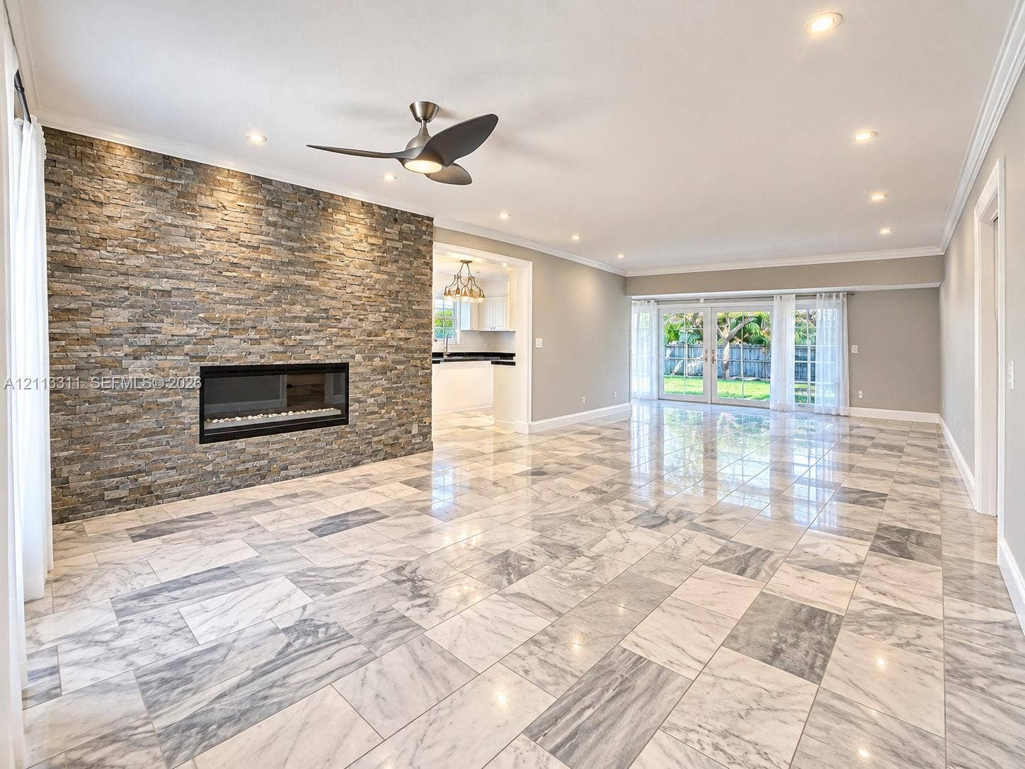 152 SW 59th Avenue, Plantation, Plantation, FL 33317 Open-concept space featuring a floor-to-ceiling stacked-stone fireplace, polished stone flooring, recessed lighting, and glass-paneled double doors