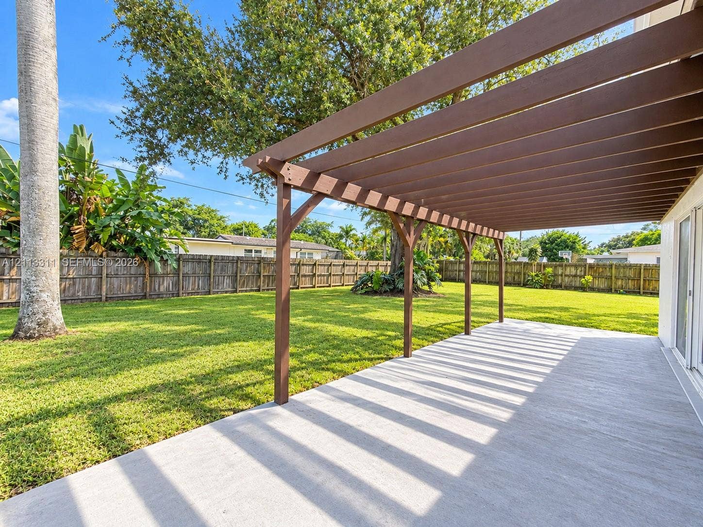 152 SW 59th Avenue, Plantation, Plantation, FL 33317 Concrete patio featuring a wooden pergola, expansive fenced-in backyard, and mature landscaping