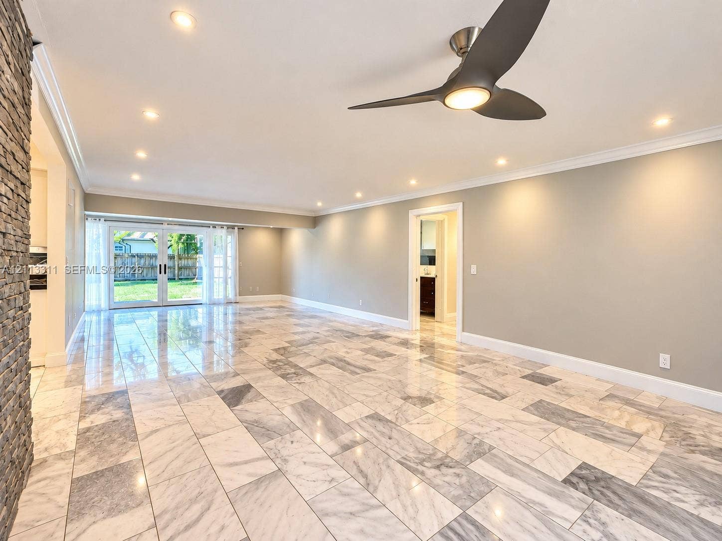 152 SW 59th Avenue, Plantation, Plantation, FL 33317 Polished tile flooring, crown molding, stone-accented pillar, three-blade ceiling fan with integrated lighting, and glass-paneled double doors