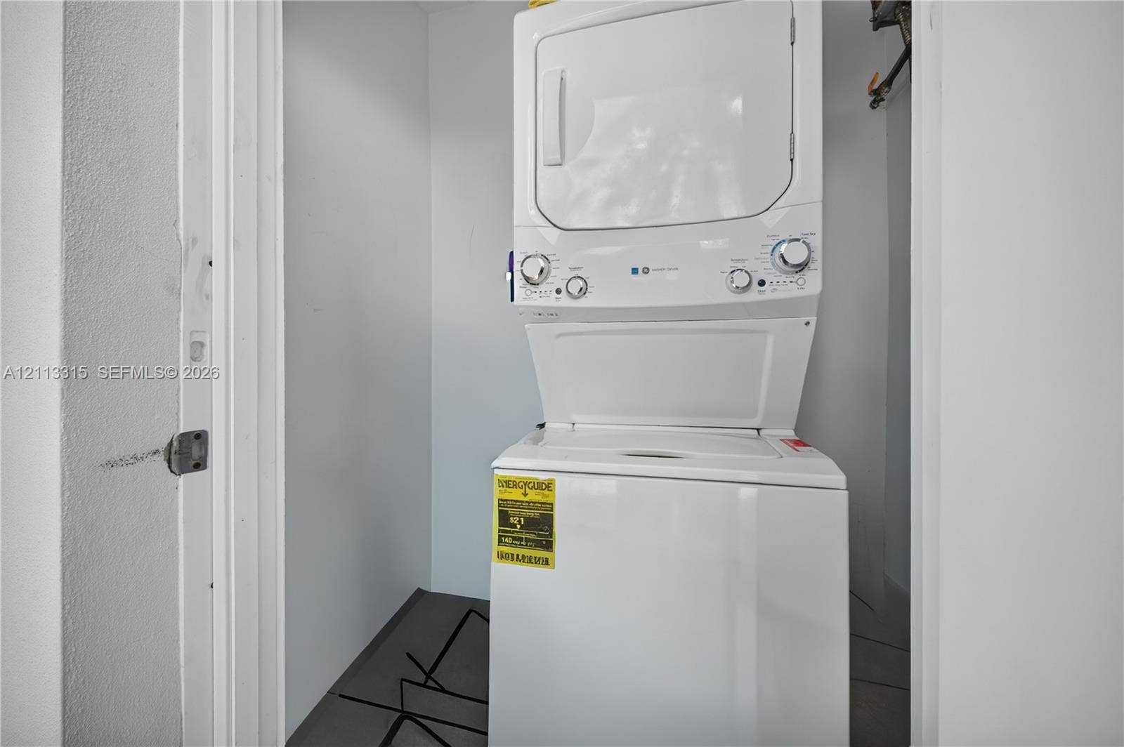 Built-in stacked laundry unit with white finish and neutral wall enclosure