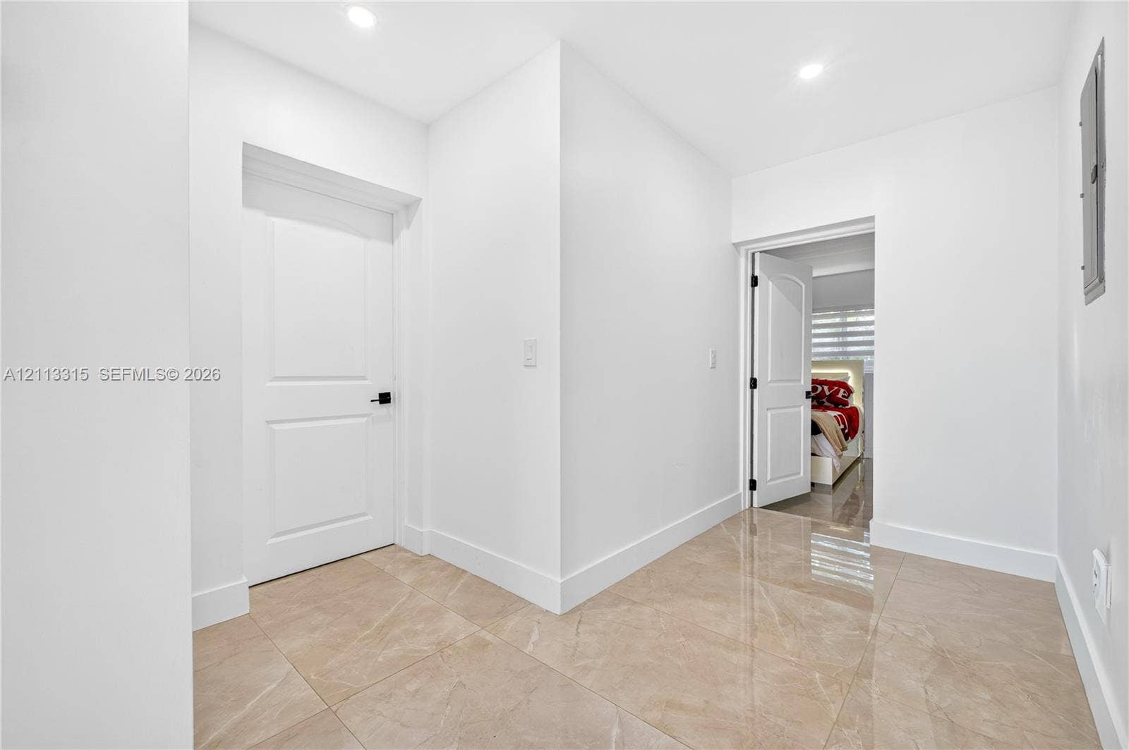 Polished tile flooring, recessed ceiling lighting, and solid-core interior doors with matte black hardware