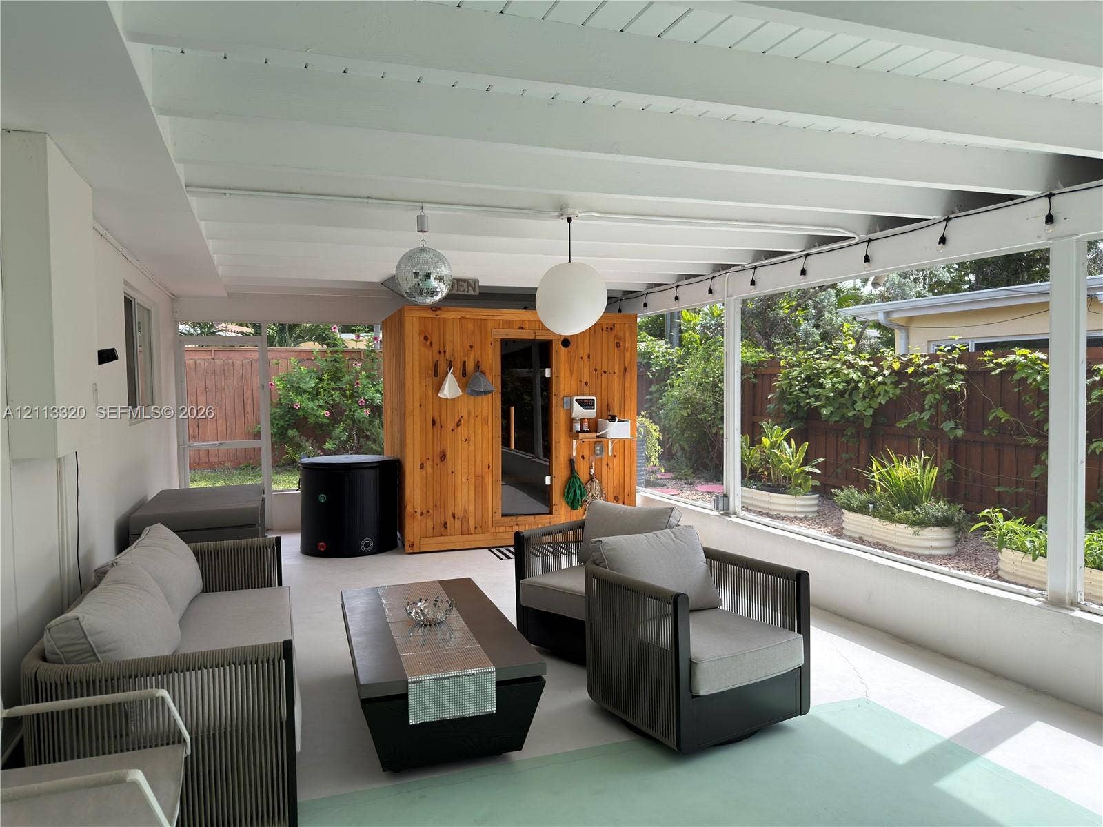 712 NE 25th Avenue, Pompano Beach, FL 33062 Screened-in patio featuring a vaulted ceiling with exposed beams, wood-paneled sauna, and concrete flooring