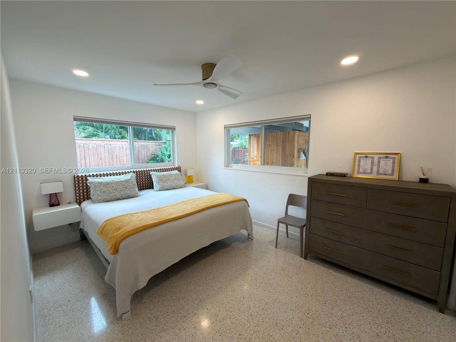 712 NE 25th Avenue, Pompano Beach, FL 33062 Terrazzo flooring, recessed ceiling lighting, wall-mounted floating bedside tables, and a three-blade ceiling fan