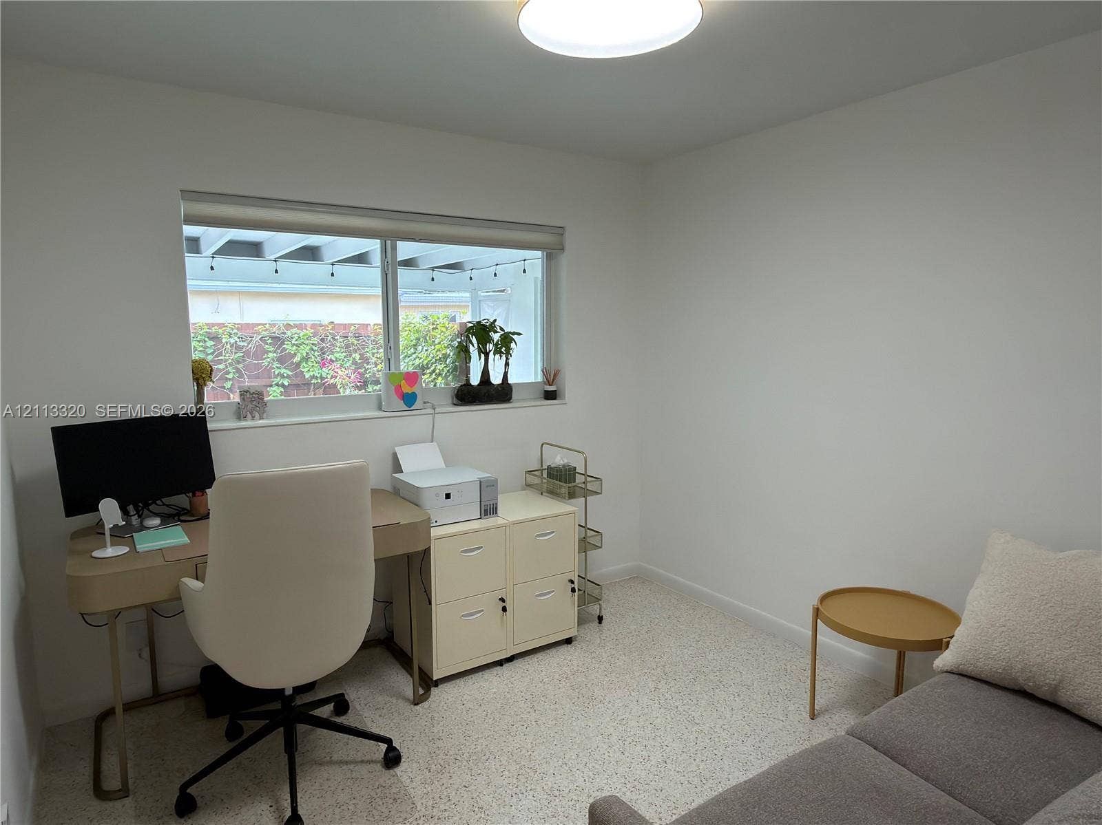 712 NE 25th Avenue, Pompano Beach, FL 33062 Neutral-toned interior space featuring light-colored stone-flecked flooring, a wide horizontal window, and a recessed ceiling lighting fixture