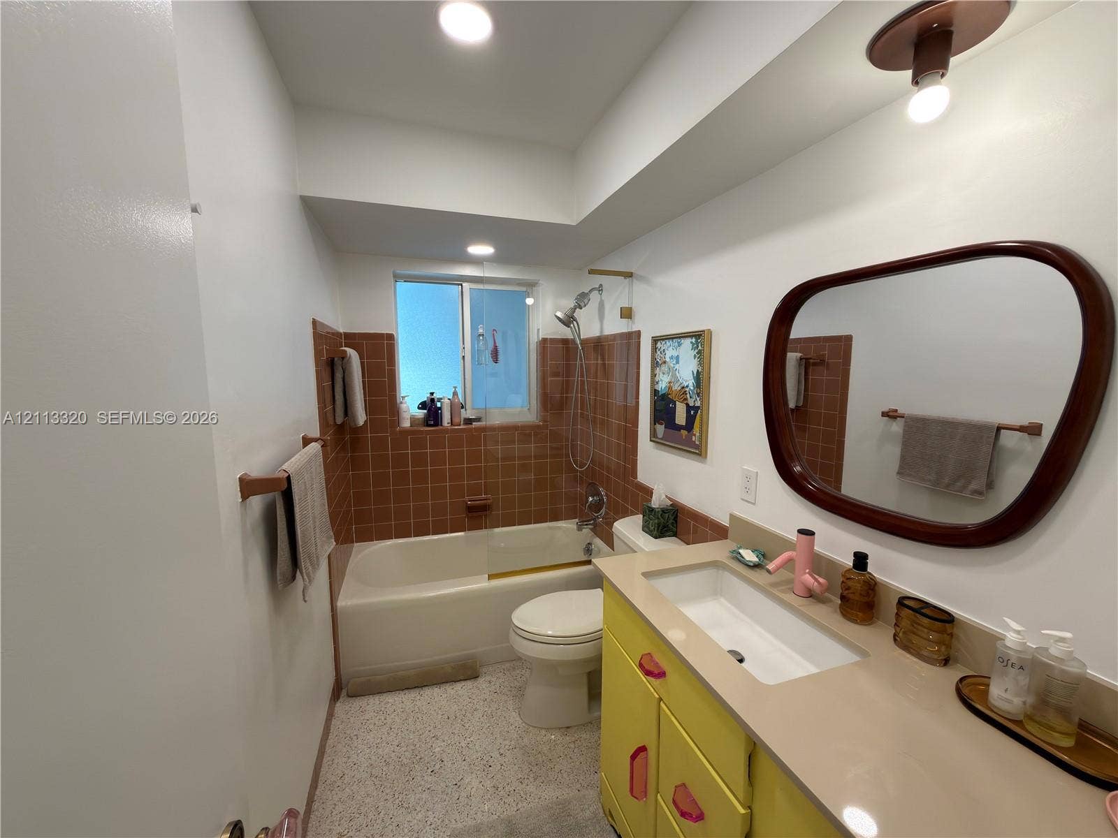 712 NE 25th Avenue, Pompano Beach, FL 33062 Bathroom featuring a vanity with integrated rectangular sink, solid surface countertop, tiled tub surround, recessed lighting, and terrazzo-style flooring