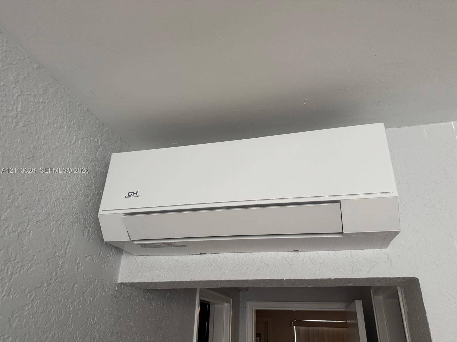 Hallandale Beach, FL 33009 Wall-mounted ductless HVAC unit featuring a white finish and minimalist casing
