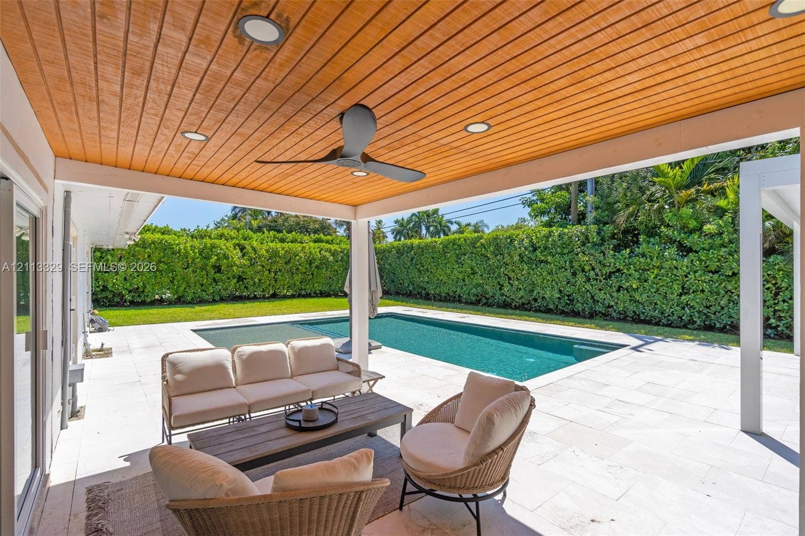 6440 SW 144th Street, Coral Gables, FL 33158 Covered patio featuring a wood-plank ceiling, recessed lighting, and a ceiling fan, opening to a stone-paved pool deck and in-ground swimming pool