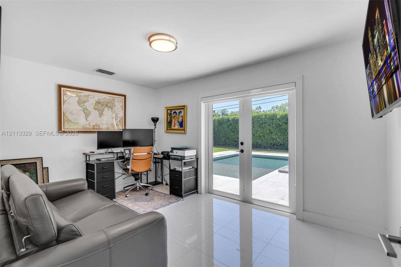 6440 SW 144th Street, Coral Gables, FL 33158 Room featuring white tile flooring, flush-mount lighting, and glass-paneled double doors providing outdoor access to an in-ground pool area