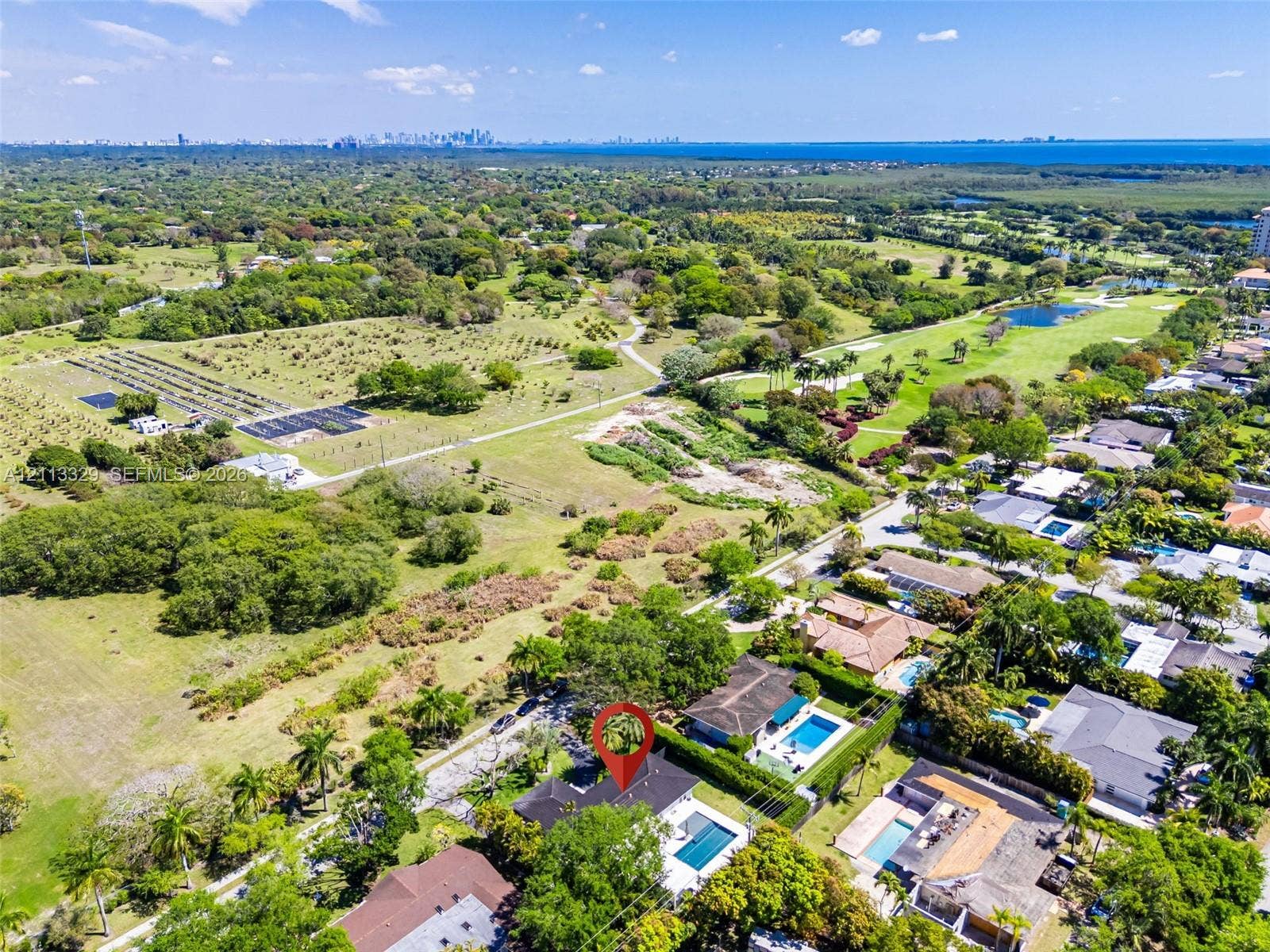 6440 SW 144th Street, Coral Gables, FL 33158 Aerial perspective featuring a residential lot with a rectangular swimming pool, concrete hardscaping, and mature perimeter landscaping