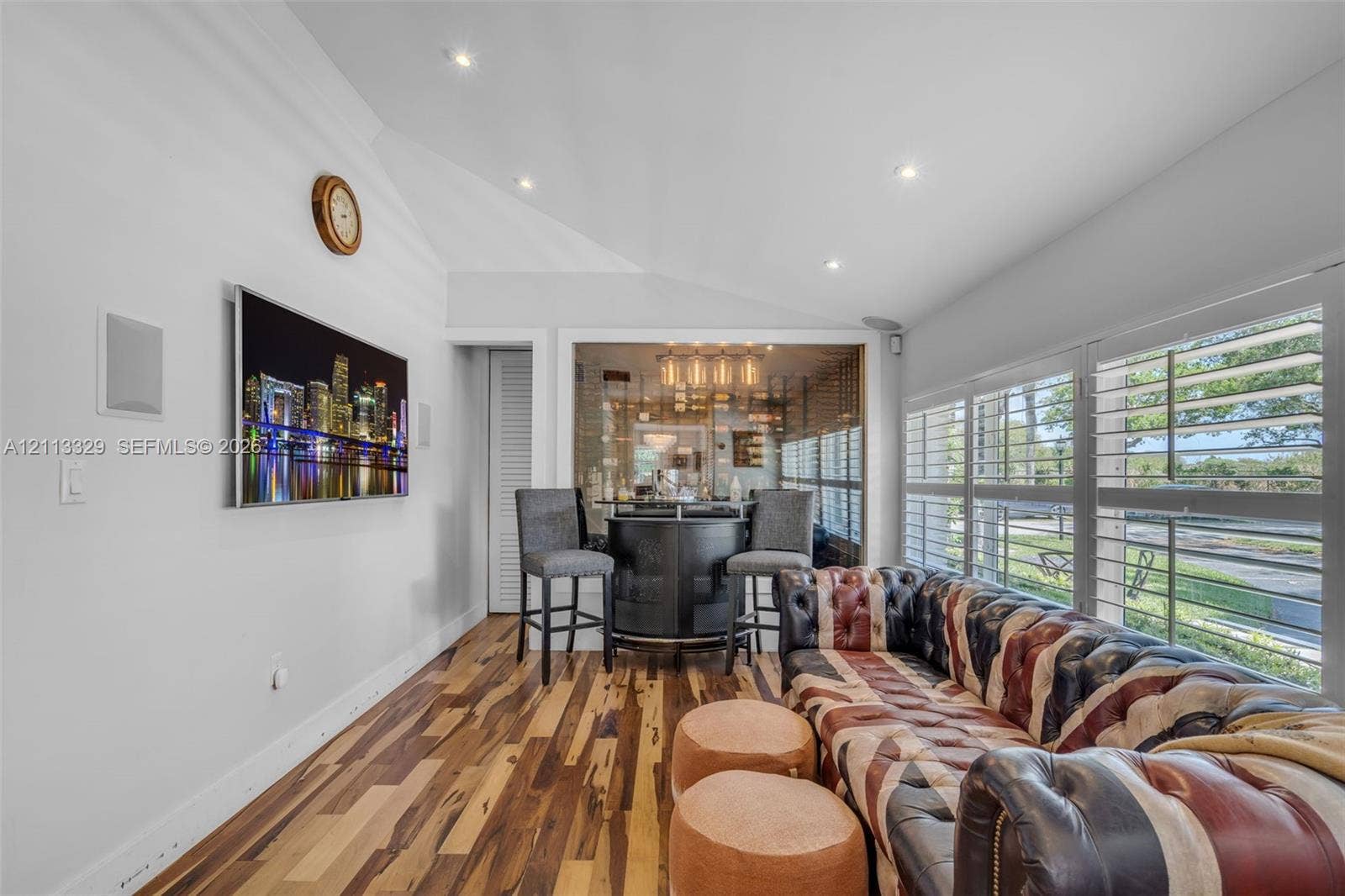 6440 SW 144th Street, Coral Gables, FL 33158 Vaulted ceilings with recessed lighting, wood-finish flooring, glass-enclosed storage area, and plantation shutters