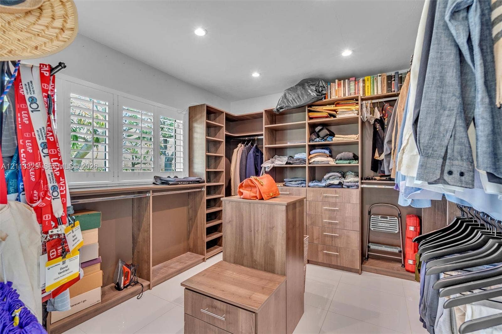 6440 SW 144th Street, Coral Gables, FL 33158 Custom walk-in closet featuring extensive built-in cabinetry, integrated drawers, recessed lighting, and white plantation shutters