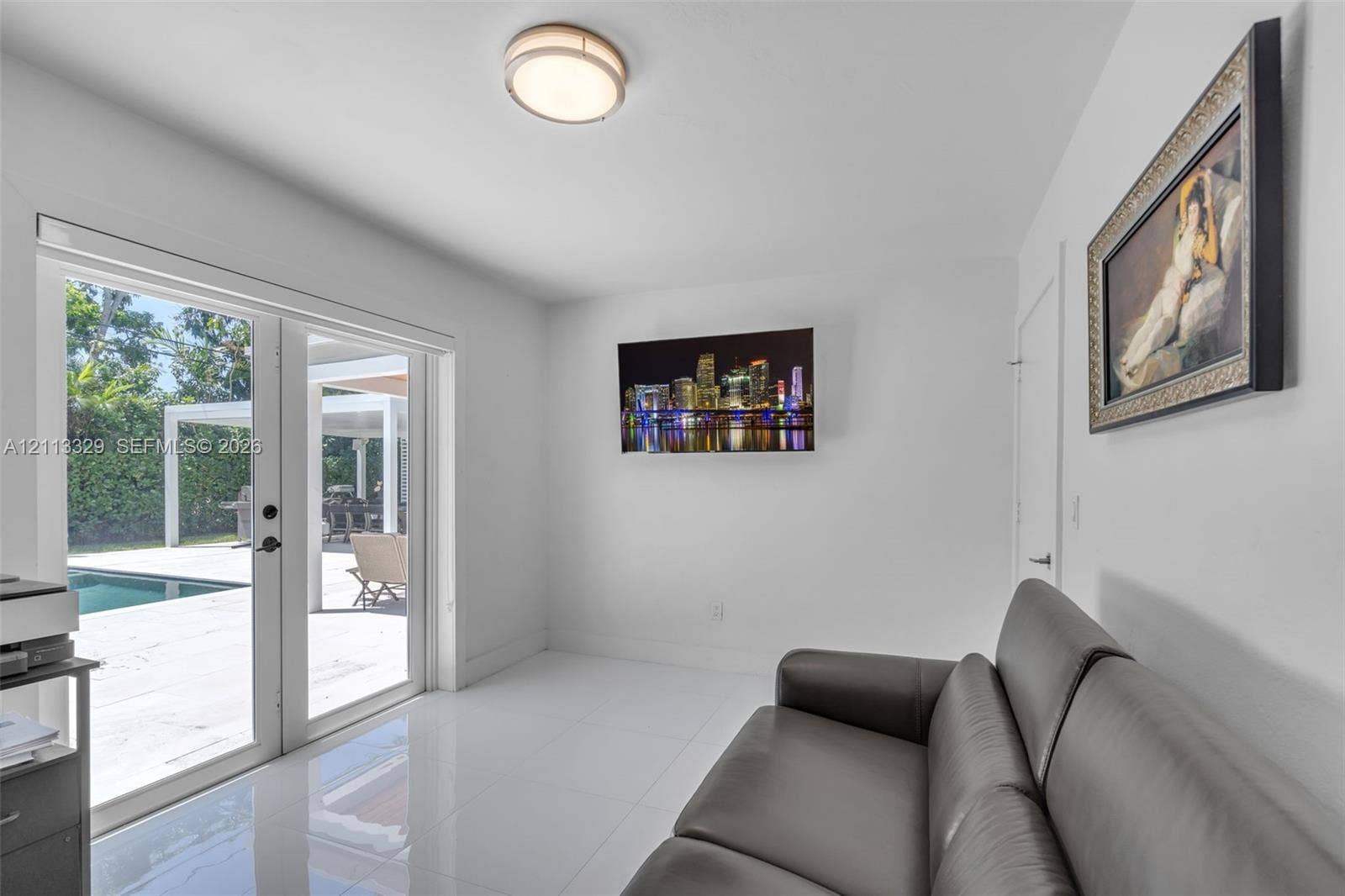 6440 SW 144th Street, Coral Gables, FL 33158 Interior space featuring polished tile flooring, flush-mount circular lighting, and glass-paned double doors opening to an exterior pool area