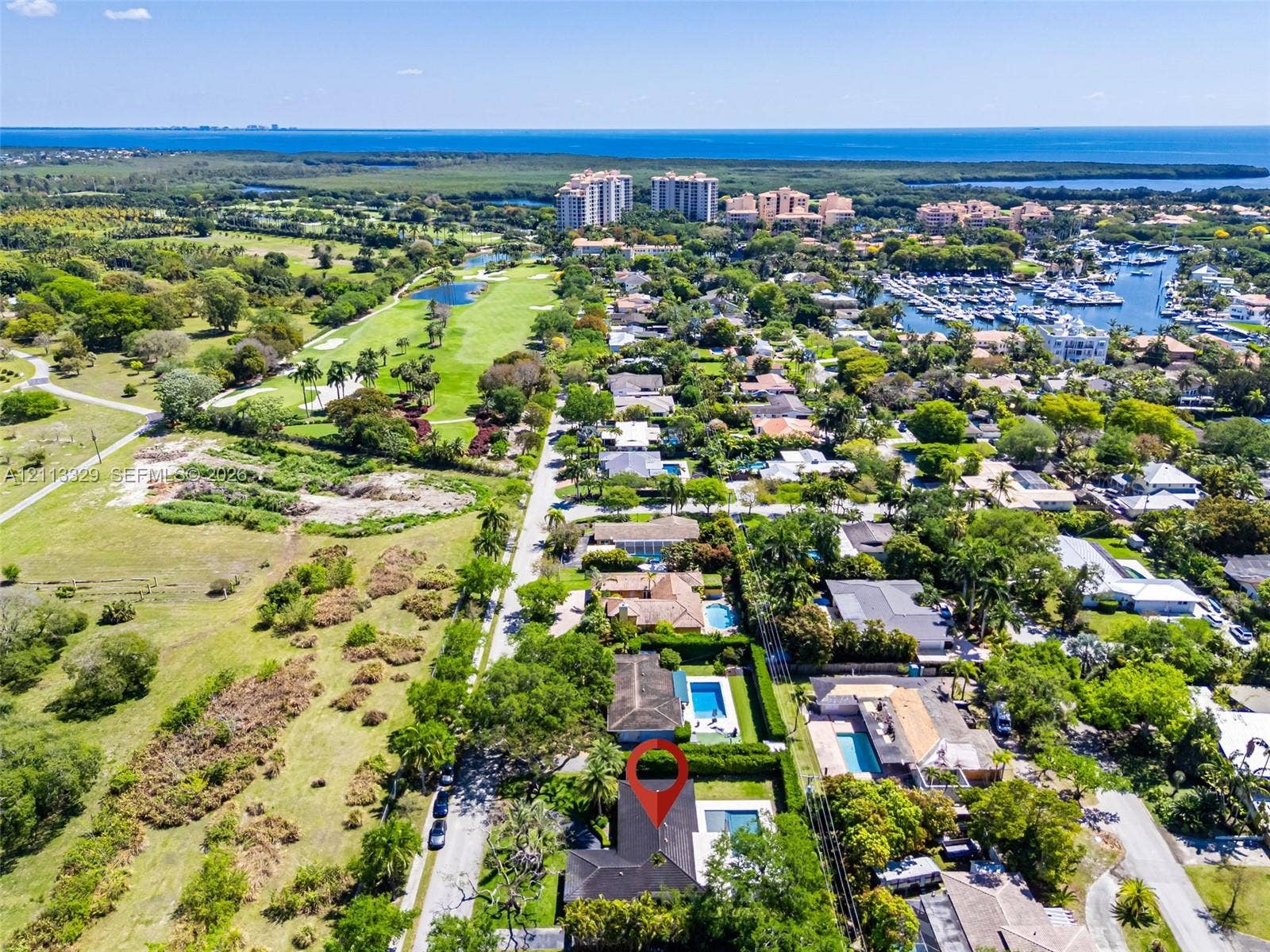 6440 SW 144th Street, Coral Gables, FL 33158 Aerial perspective showcasing a residential property featuring a private swimming pool, mature perimeter landscaping, and proximity to regional coastal waterways and golf course grounds