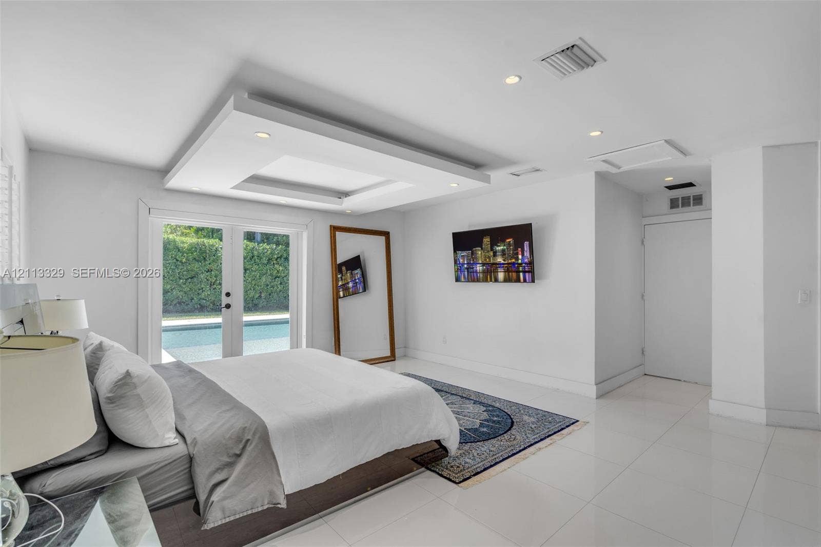 6440 SW 144th Street, Coral Gables, FL 33158 Tray ceiling with recessed lighting, tile flooring, and glass-paneled double doors providing outdoor access