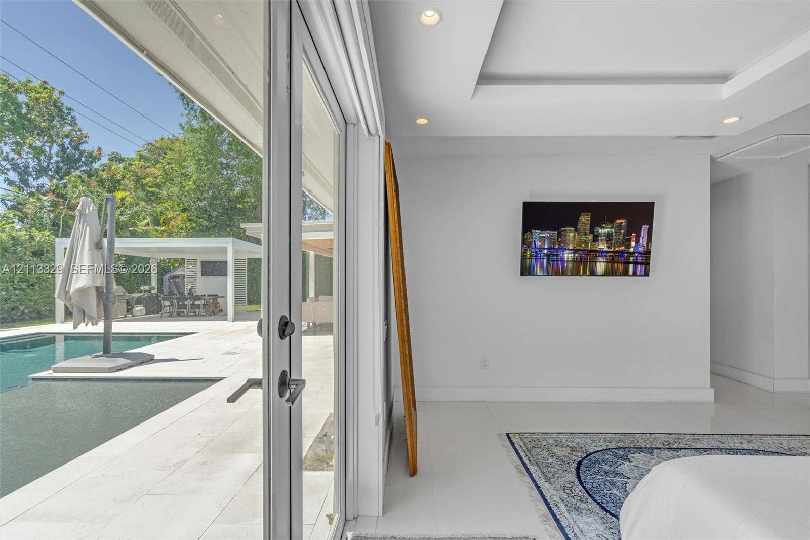 6440 SW 144th Street, Coral Gables, FL 33158 Floor-to-ceiling glass panel doors, tray ceiling with recessed lighting, and polished stone-finish flooring