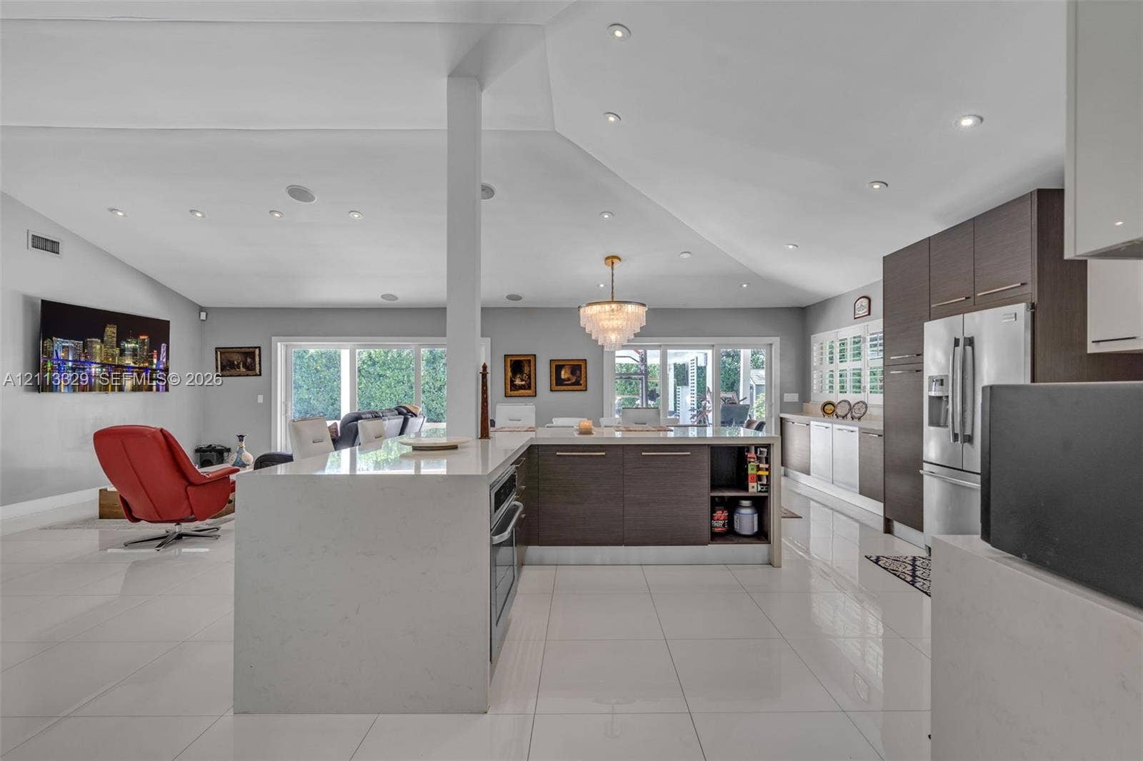 6440 SW 144th Street, Coral Gables, FL 33158 Open-concept kitchen featuring an oversized island with a solid surface countertop, flat-panel cabinetry, recessed ceiling lighting, and porcelain tile flooring