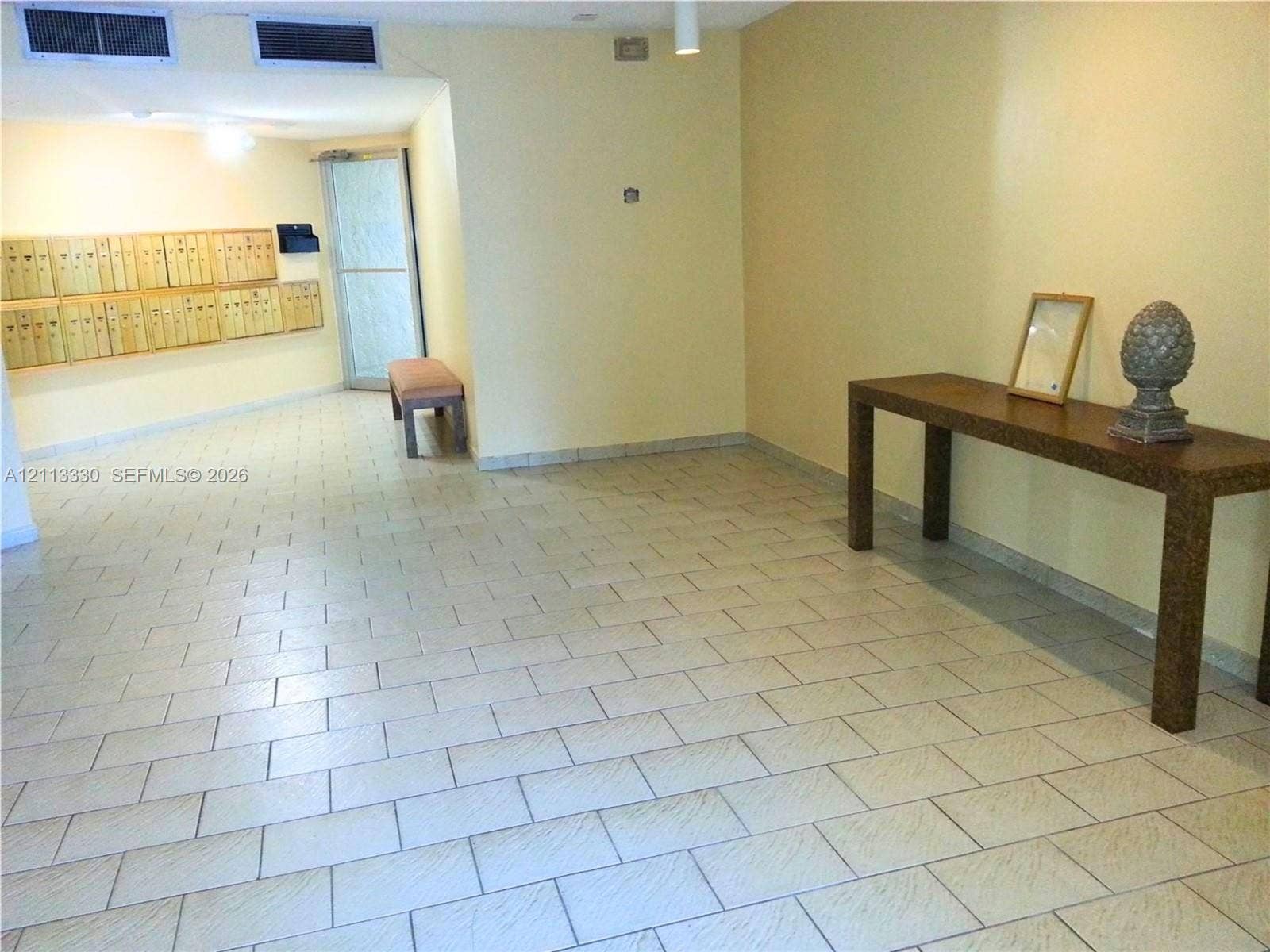 6001 N Falls Cir Drive, #105, Lauderhill, FL 33319 Common area featuring large-format ceramic tile flooring, recessed ceiling lighting, and integrated wall-mounted mailboxes