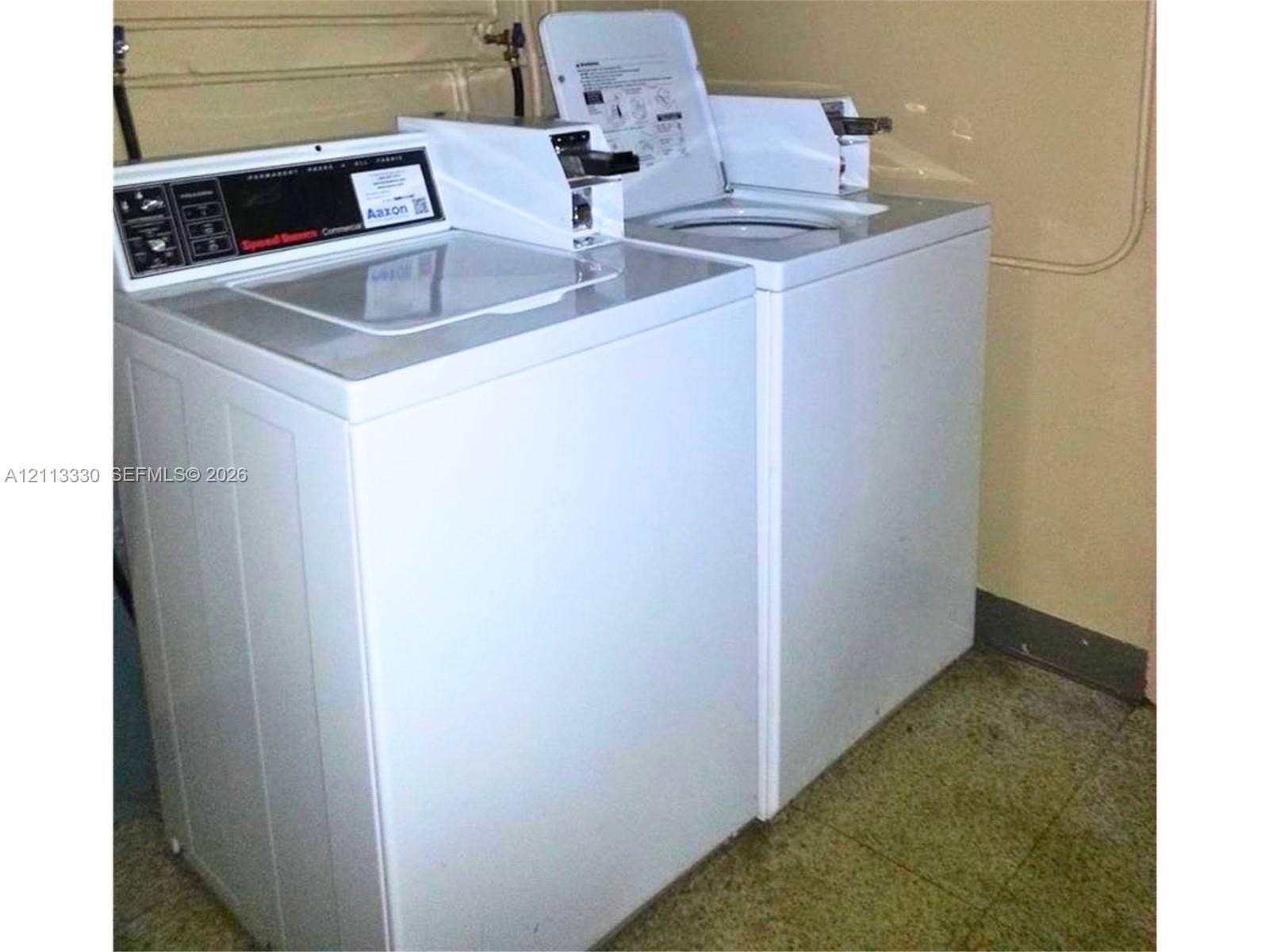 6001 N Falls Cir Drive, #105, Lauderhill, FL 33319 Utility area featuring white top-loading laundry appliances and solid-surface flooring