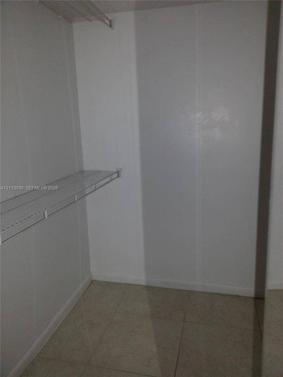 6001 N Falls Cir Drive, #105, Lauderhill, FL 33319 Storage space featuring white walls, large-format tile flooring, and metal wire shelving