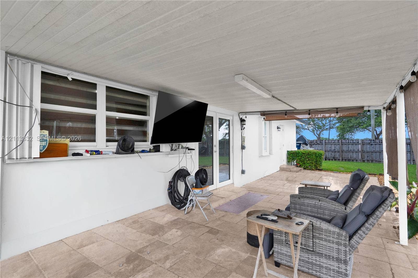 13111 SW 84th Street, Miami, FL 33183 Covered outdoor patio featuring light-toned tile flooring, recessed ceiling lighting, and exterior access via glass-paneled doors