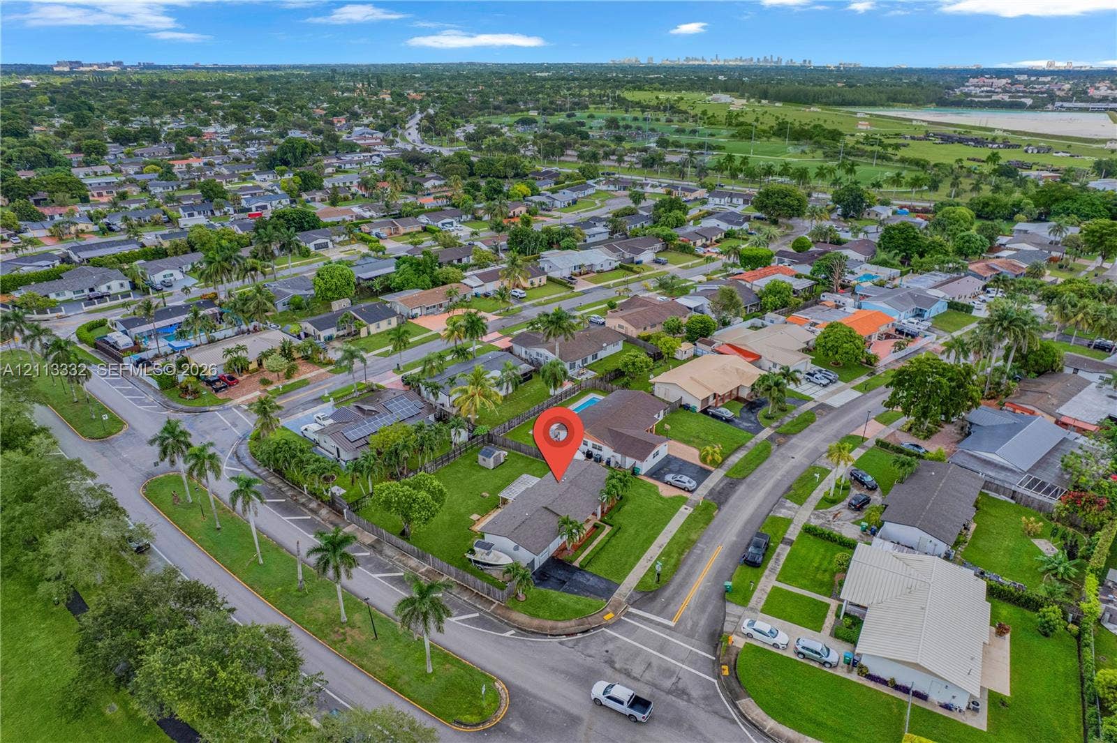 13111 SW 84th Street, Miami, FL 33183 Aerial perspective of corner lot featuring a fenced backyard, private swimming pool, mature palm trees, and asphalt driveway