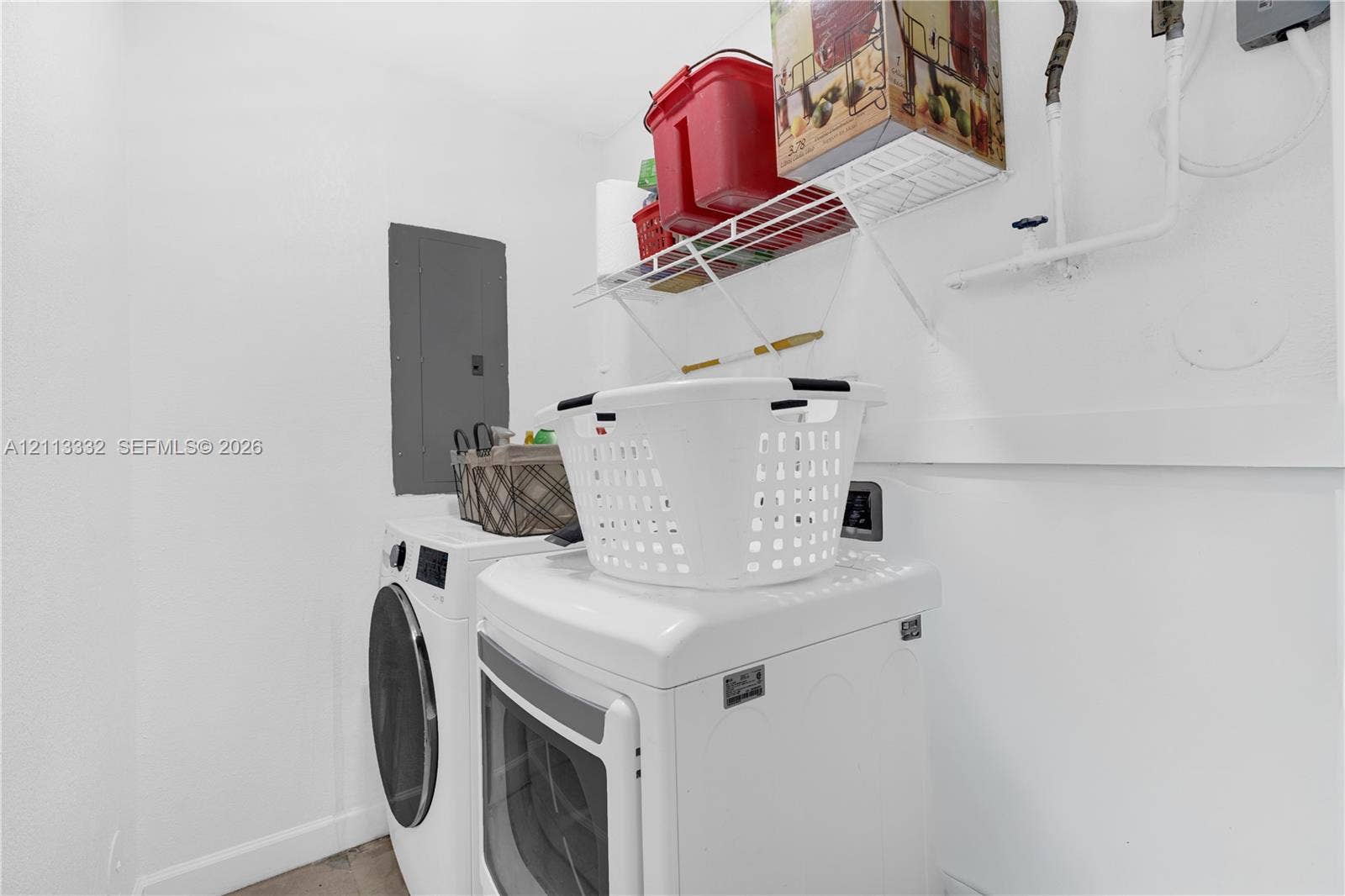 13111 SW 84th Street, Miami, FL 33183 Dedicated laundry area featuring white walls, wire shelving, and an electrical service panel
