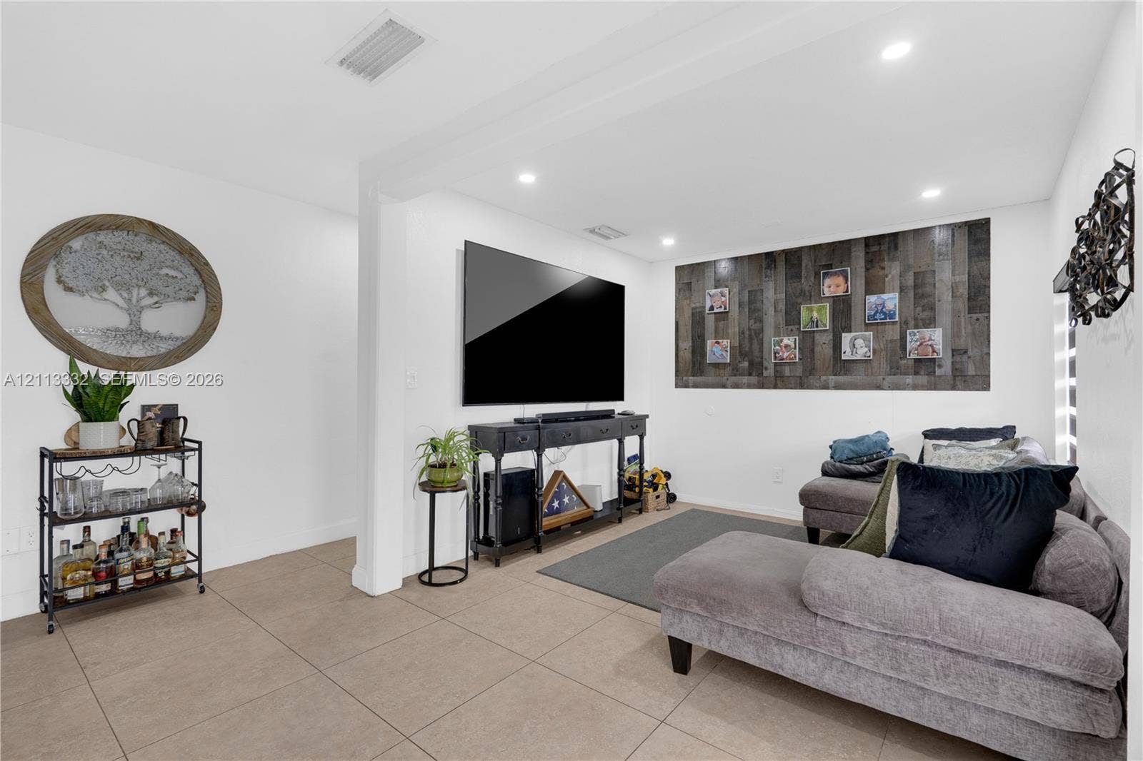 13111 SW 84th Street, Miami, FL 33183 Neutral-toned tile flooring, recessed ceiling lighting, and a textured wood-plank accent wall