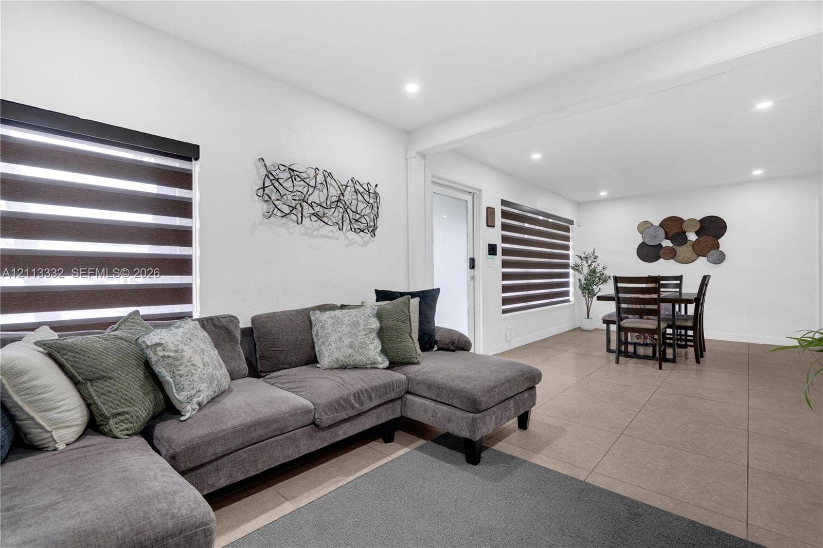 13111 SW 84th Street, Miami, FL 33183 Open concept interior featuring large-format tile flooring, recessed lighting, and windows equipped with dual-layered roller shades