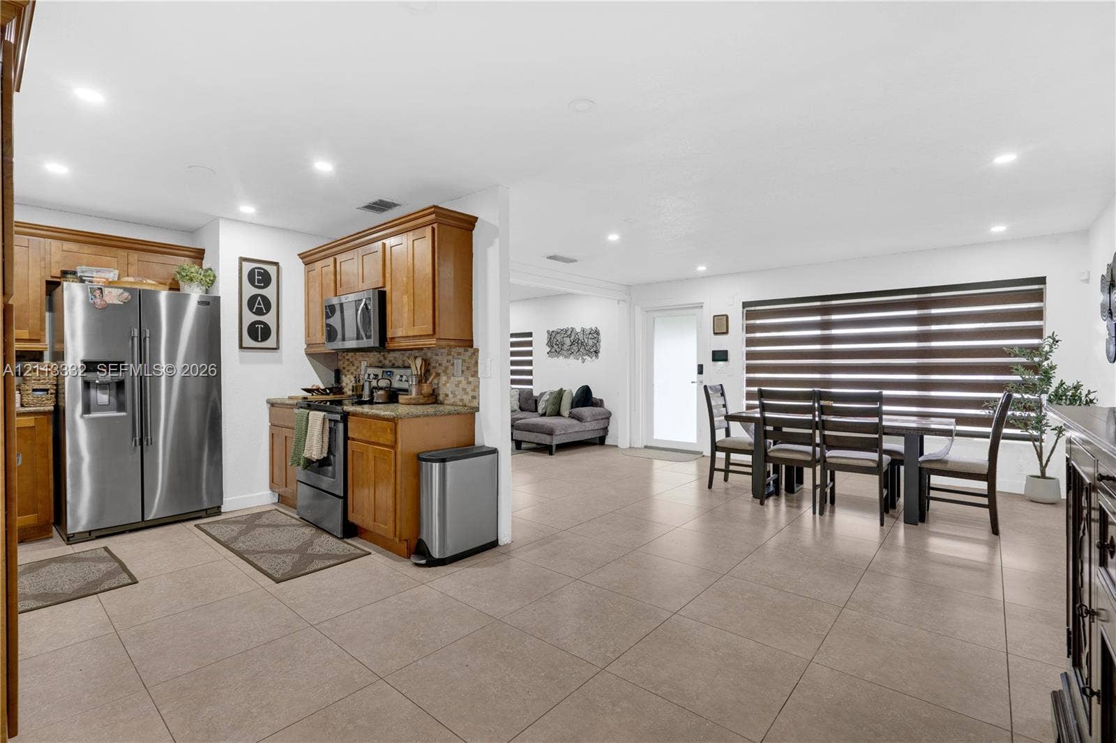 13111 SW 84th Street, Miami, FL 33183 Kitchen featuring wood cabinetry, stone countertops, stainless steel appliances, recessed lighting, and large-format tile flooring