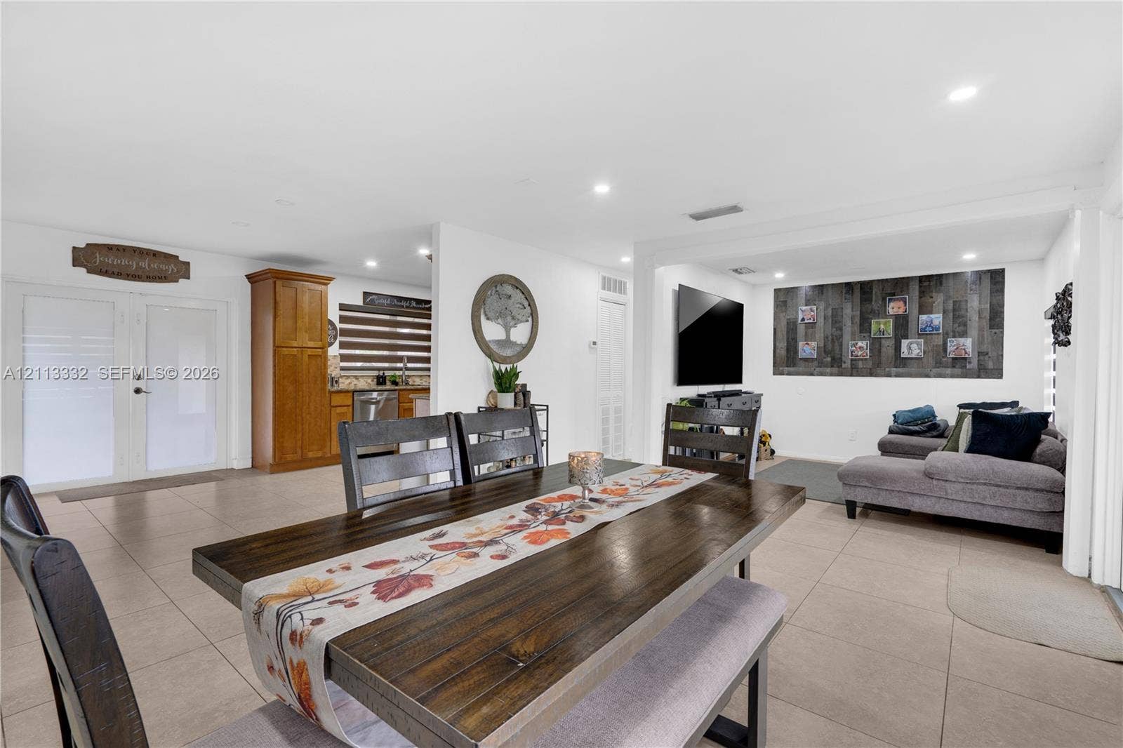 13111 SW 84th Street, Miami, FL 33183 Open-concept interior featuring large-format tile flooring, recessed lighting, double-door entryway, and vertical plank accent wall