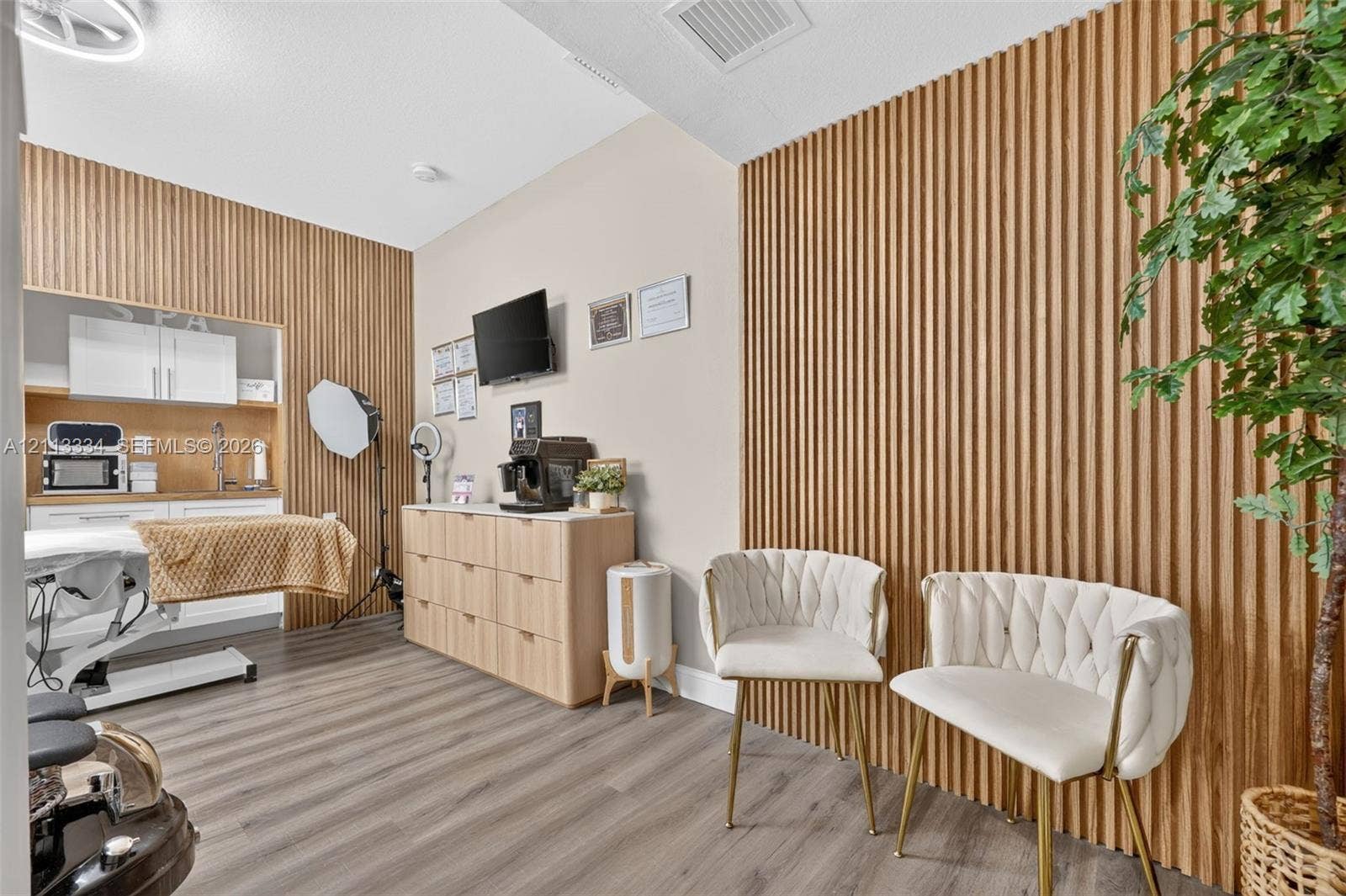 28232 SW 128th Path, Homestead, FL 33033 Vertical slat wood paneling on feature walls, integrated cabinetry with a built-in sink, and wood-finish flooring