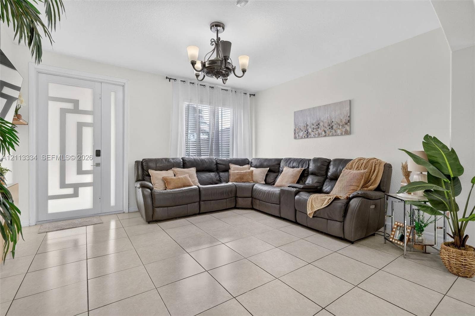 28232 SW 128th Path, Homestead, FL 33033 Neutral tile flooring, decorative front door with geometric glass inlay, and five-arm transitional chandelier