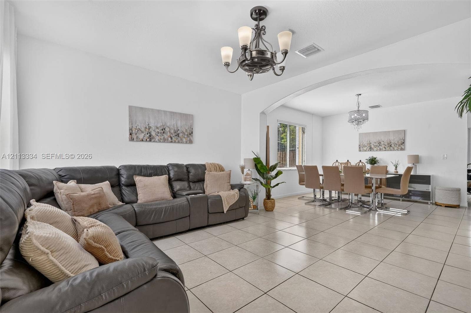 28232 SW 128th Path, Homestead, FL 33033 Neutral tile flooring, arched wall detailing, wrought-iron style multi-light chandelier, and decorative ceiling light fixtures