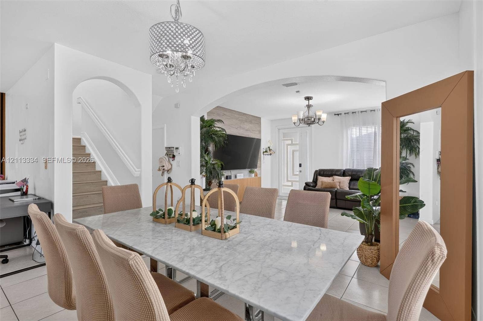 28232 SW 128th Path, Homestead, FL 33033 Open-concept interior featuring arched architectural detailing, tile flooring, and decorative multi-tiered pendant lighting