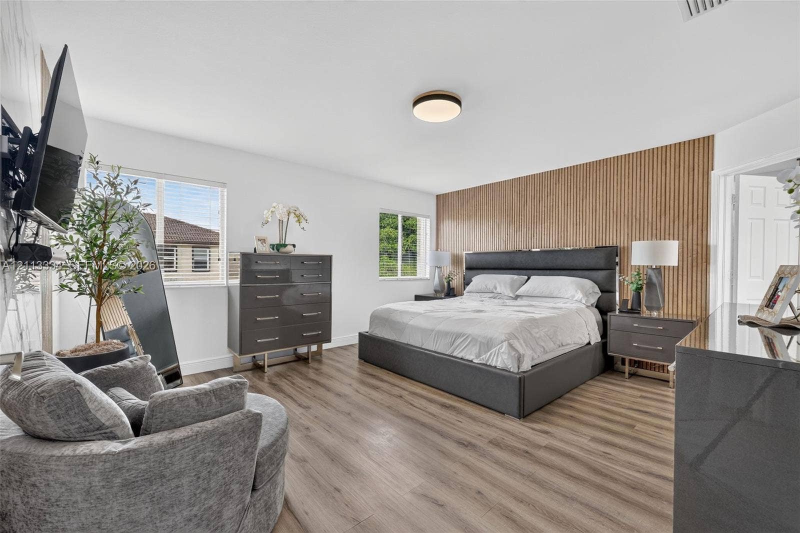 28232 SW 128th Path, Homestead, FL 33033 Wood-finish flooring, vertical wood-slat accent wall, and flush-mount ceiling lighting