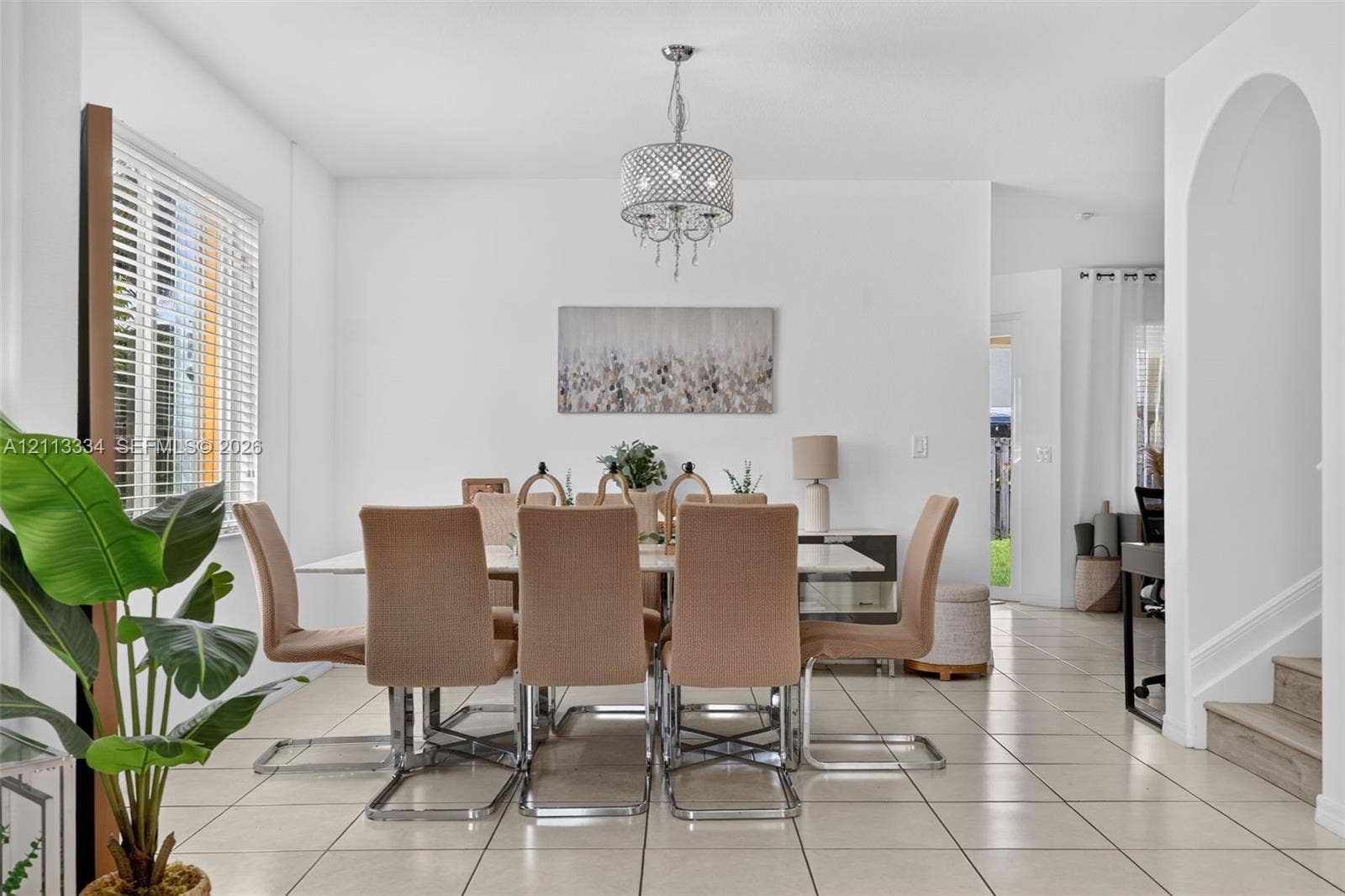 28232 SW 128th Path, Homestead, FL 33033 Dining area featuring neutral tile flooring, a multi-light drum chandelier, an arched entryway, and white walls