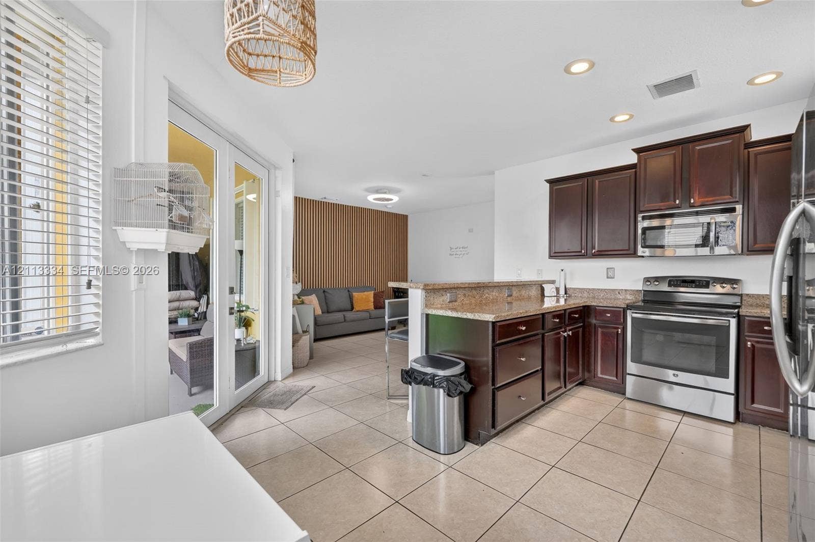28232 SW 128th Path, Homestead, FL 33033 Kitchen featuring dark wood cabinetry, stone countertops, stainless steel appliances, tile flooring, and recessed lighting