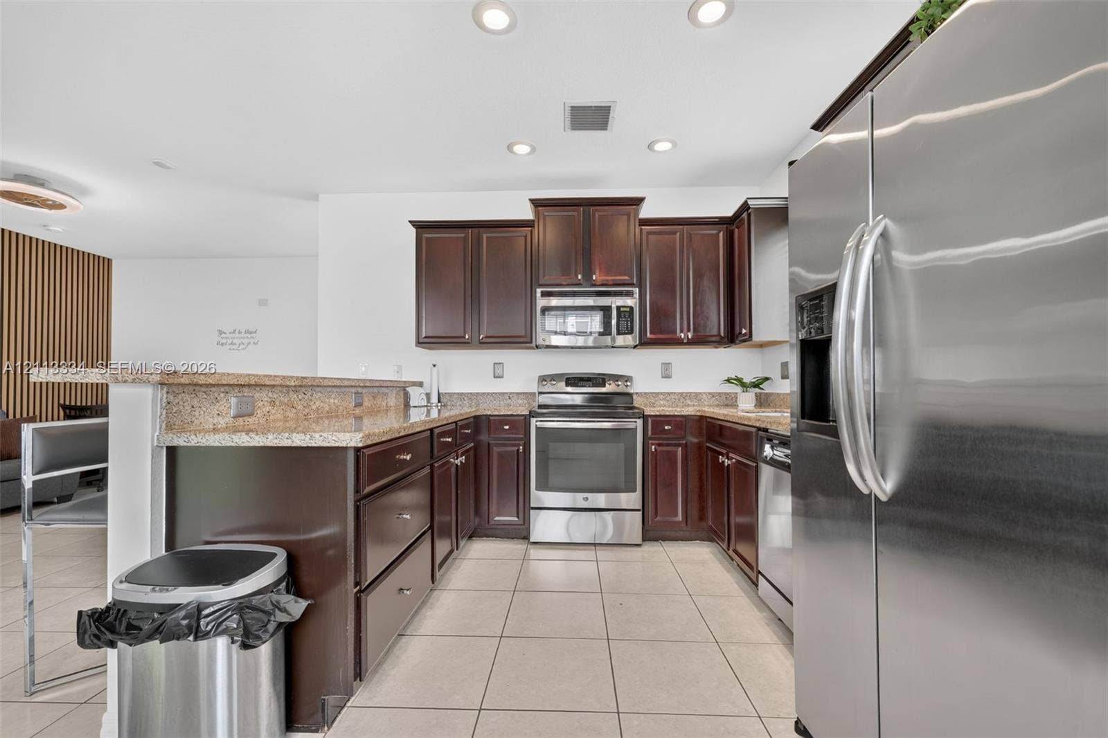 28232 SW 128th Path, Homestead, FL 33033 Kitchen featuring dark-toned wood cabinetry, stone countertops, stainless steel appliances, and ceramic tile flooring