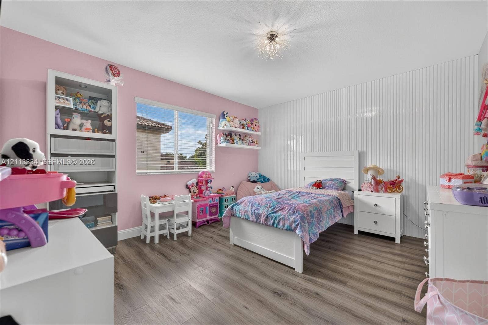 28232 SW 128th Path, Homestead, FL 33033 Wood-finish flooring, vertical slat wall paneling, built-in recessed shelving unit, and a ceiling-mounted crystal-style light fixture