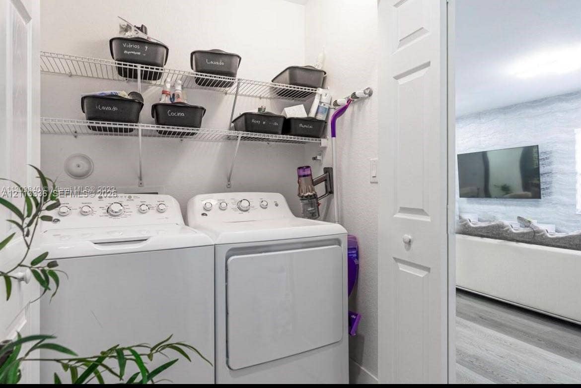 Laundry area featuring white top-loading appliances and dual-tier wire shelving