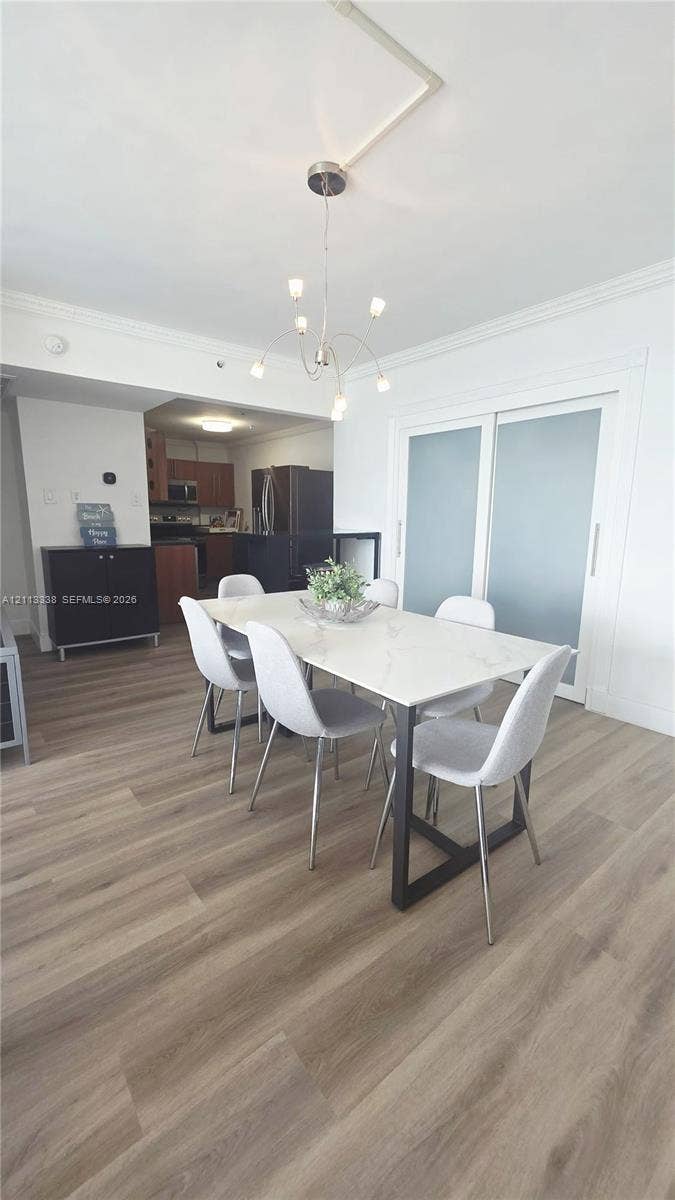 3001 S Ocean Drive, #1539, Hollywood, Hollywood, FL 33019 Wood-finish flooring, multi-arm chrome chandelier, and sliding doors with frosted glass panels