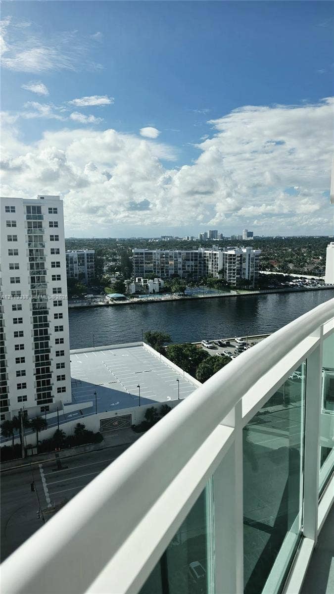 3001 S Ocean Drive, #1539, Hollywood, Hollywood, FL 33019 Elevated balcony with glass panel railing and painted metal frame overlooking waterway and urban skyline
